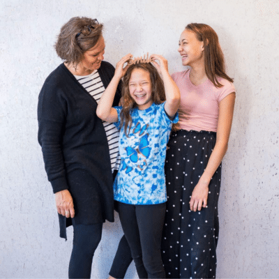 Orthodontics for all ages 10 Two female adults with a teenage girl, smiling and laughing, representing orthodontics for all ages