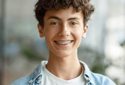 Traditional metal braces: pros and cons 10 Teenage boy smiling, wearing traditional metal braces