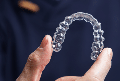 How clear aligners work: the process from start to finish 10 A person holding clear aligners up, representing how clear aligners work