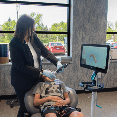 Dr. Heather horton using advanced orthodontic technology to see a patient's teeth on a tv monitor