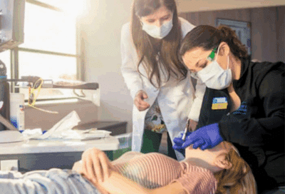 Choosing the right orthodontic treatment options: big fix or little tweak? 4 Dr. Horton with a member of her team working on a teenage girl's teeth, representing orthodontic treatment options